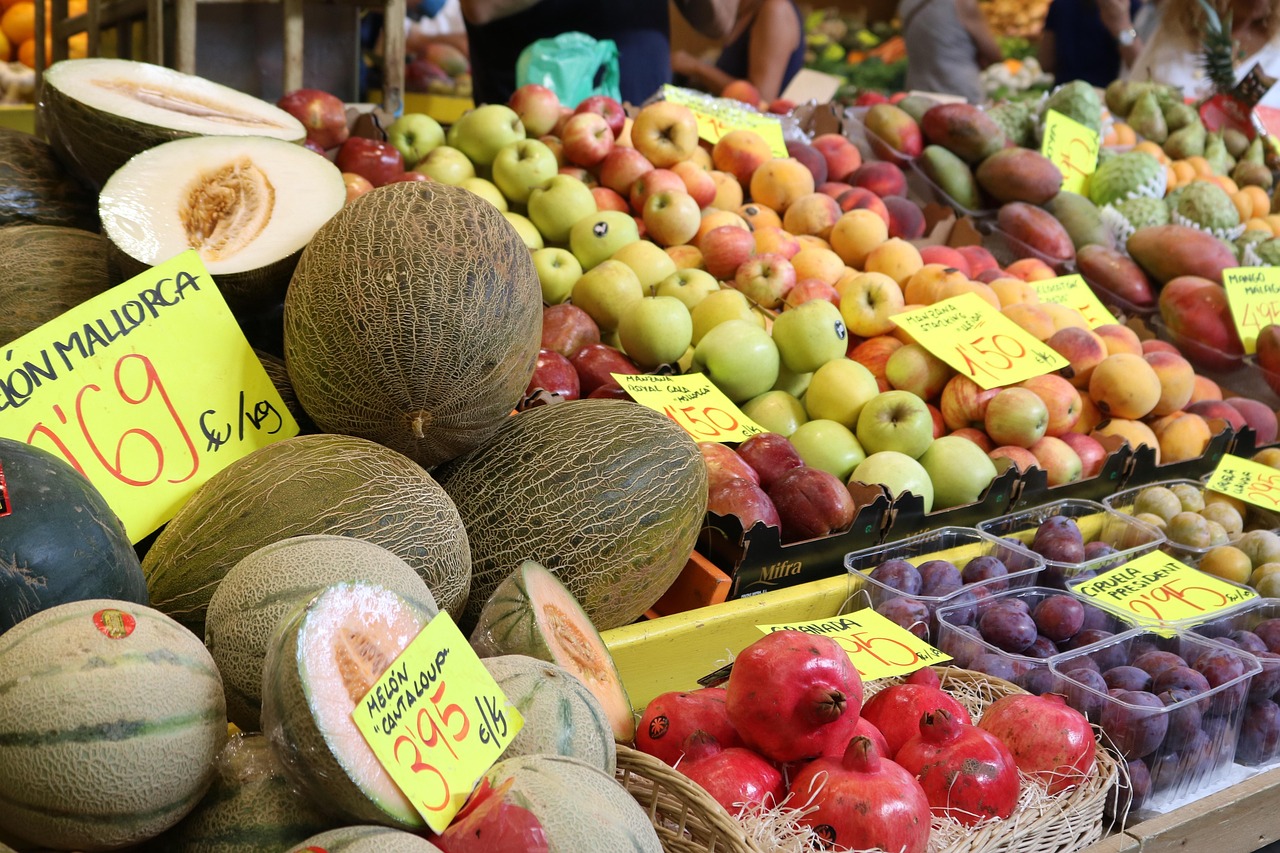 Mercados semanales de Mallorca: Sineu, Inca, Llucmajor y más 2 Vendedor en mercado semanal mostrando frutas y verduras frescas de la región sur.